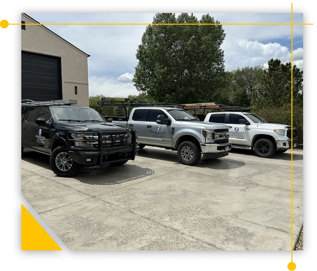 Three trucks are parked in a parking lot in front of a building.